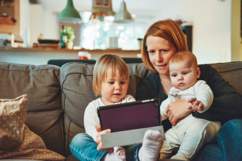 a woman sits with two young children