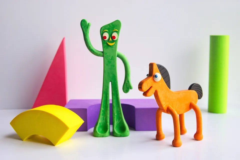 a toy gumby standing next to a toy horse