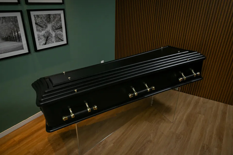 a black coffin in a funeral parlor