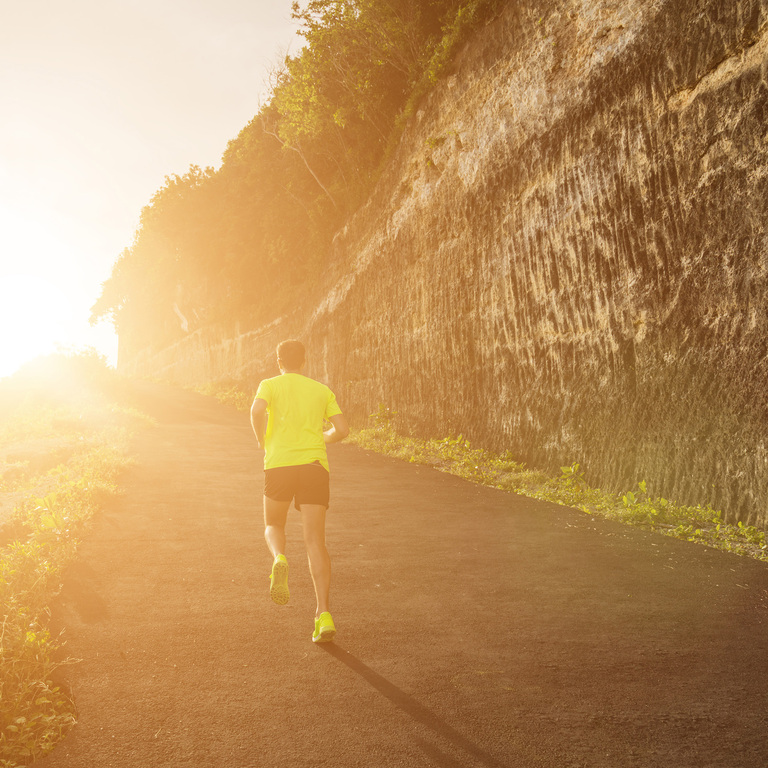 Runner approaching a steep driveway hill at the end of a hot summer run