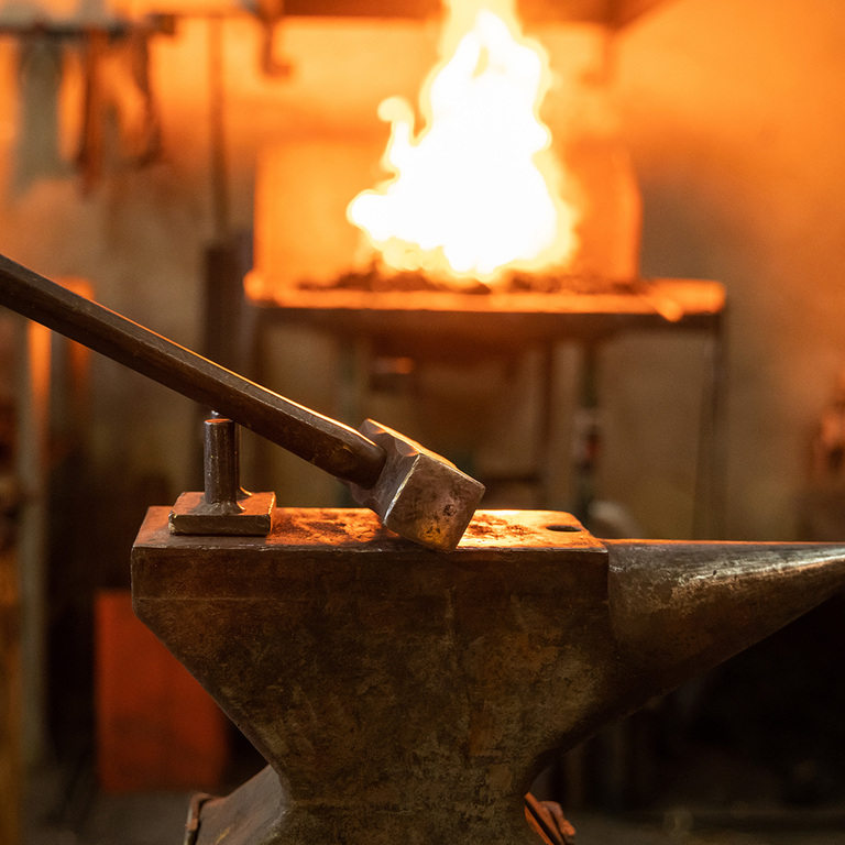 a hammer leaning on a anvil