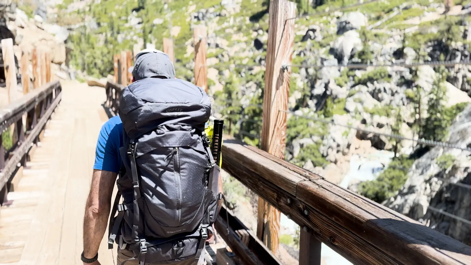 A man walking cross a rugged mountain bridge
