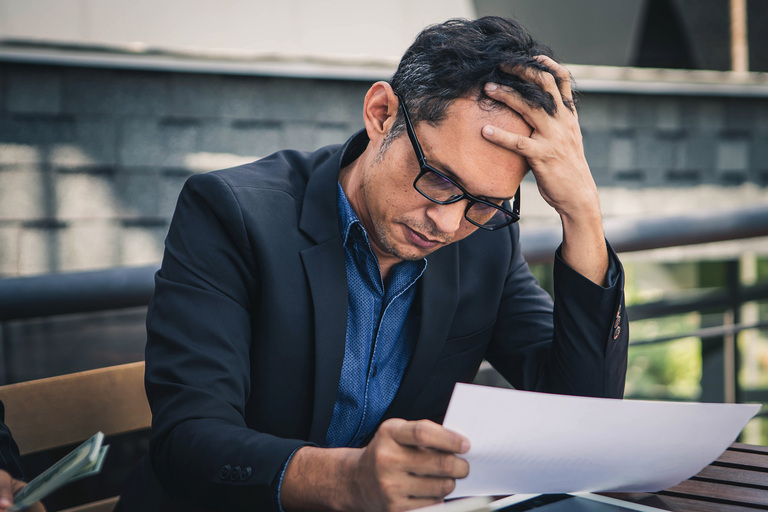 a stressed business owner reviewing financial statements