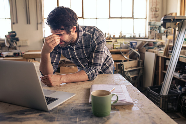 a stressed business owner reviewing financial statements